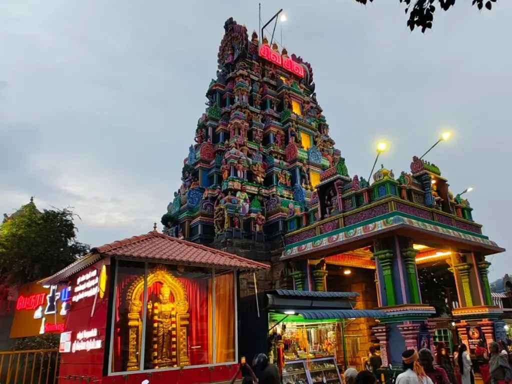 Perur Arulmigu Pateeswaraswamy Temple gopuram illuminated at dusk in Coimbatore, Tamil Nadu, showcasing traditional Dravidian temple architecture